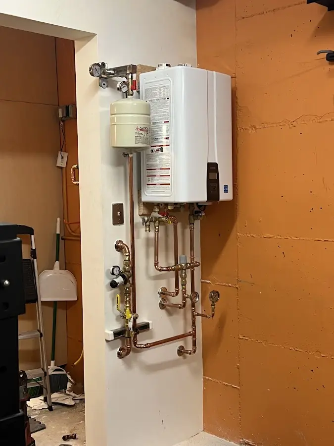Plumbing technician inspecting water heater connections in Brookridge